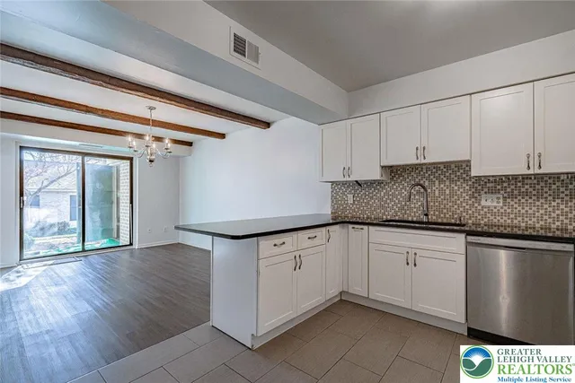 a kitchen with granite countertop white cabinets and white appliances