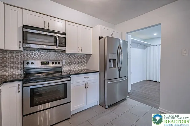 a kitchen with stainless steel appliances granite countertop a refrigerator and a stove top oven