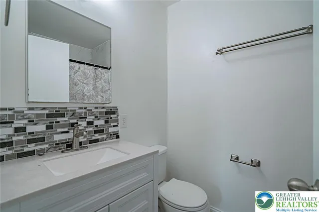 a bathroom with a granite countertop toilet and a sink