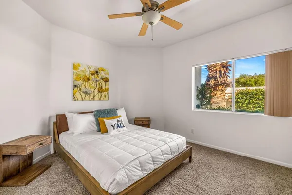 a bedroom with a bed and painting on the wall