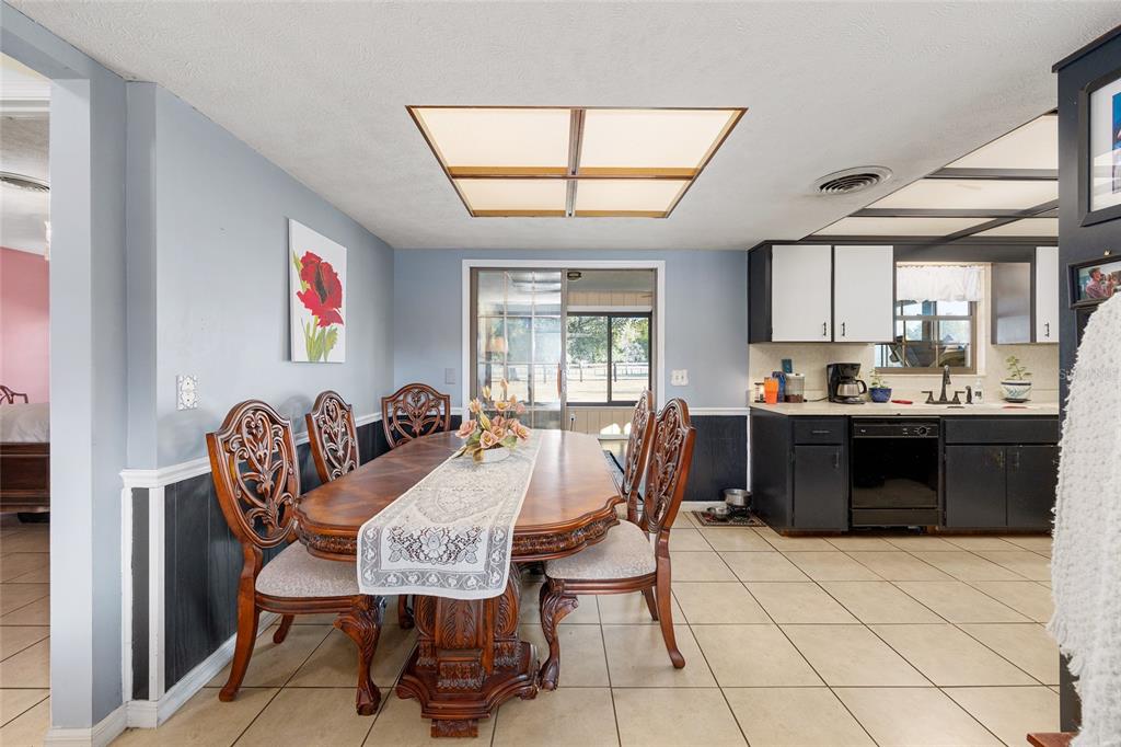 825 Northeast 165th Street Citra, FL 32113 - Photo 13 of 62 a view of kitchen with stainless steel appliances granite countertop a stove a sink a dining table and chairs