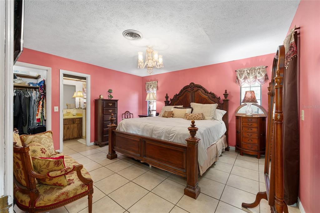 825 Northeast 165th Street Citra, FL 32113 - Photo 23 of 62 a bedroom with a bed and chair