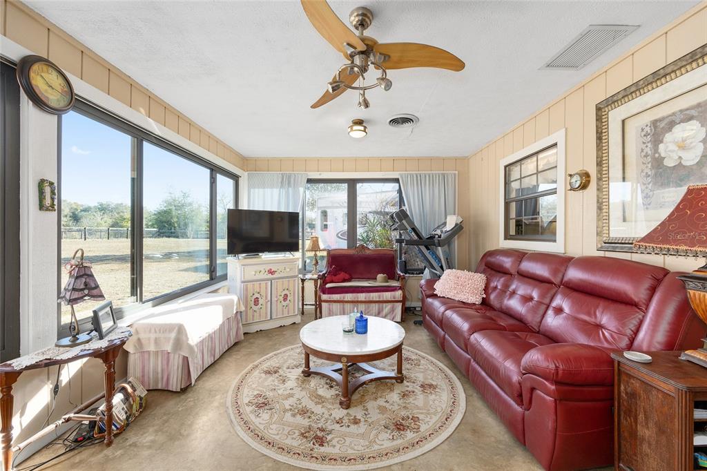 825 Northeast 165th Street Citra, FL 32113 - Photo 29 of 62 a living room with furniture a flat screen tv and a large window