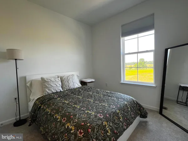 a bed sitting in a bedroom next to a window