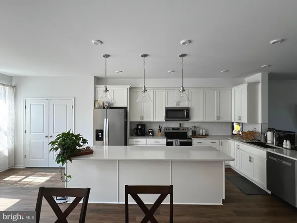 a kitchen with stainless steel appliances a white cabinets and wooden floor