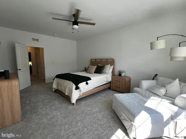 a bed room with couch and a ceiling fan