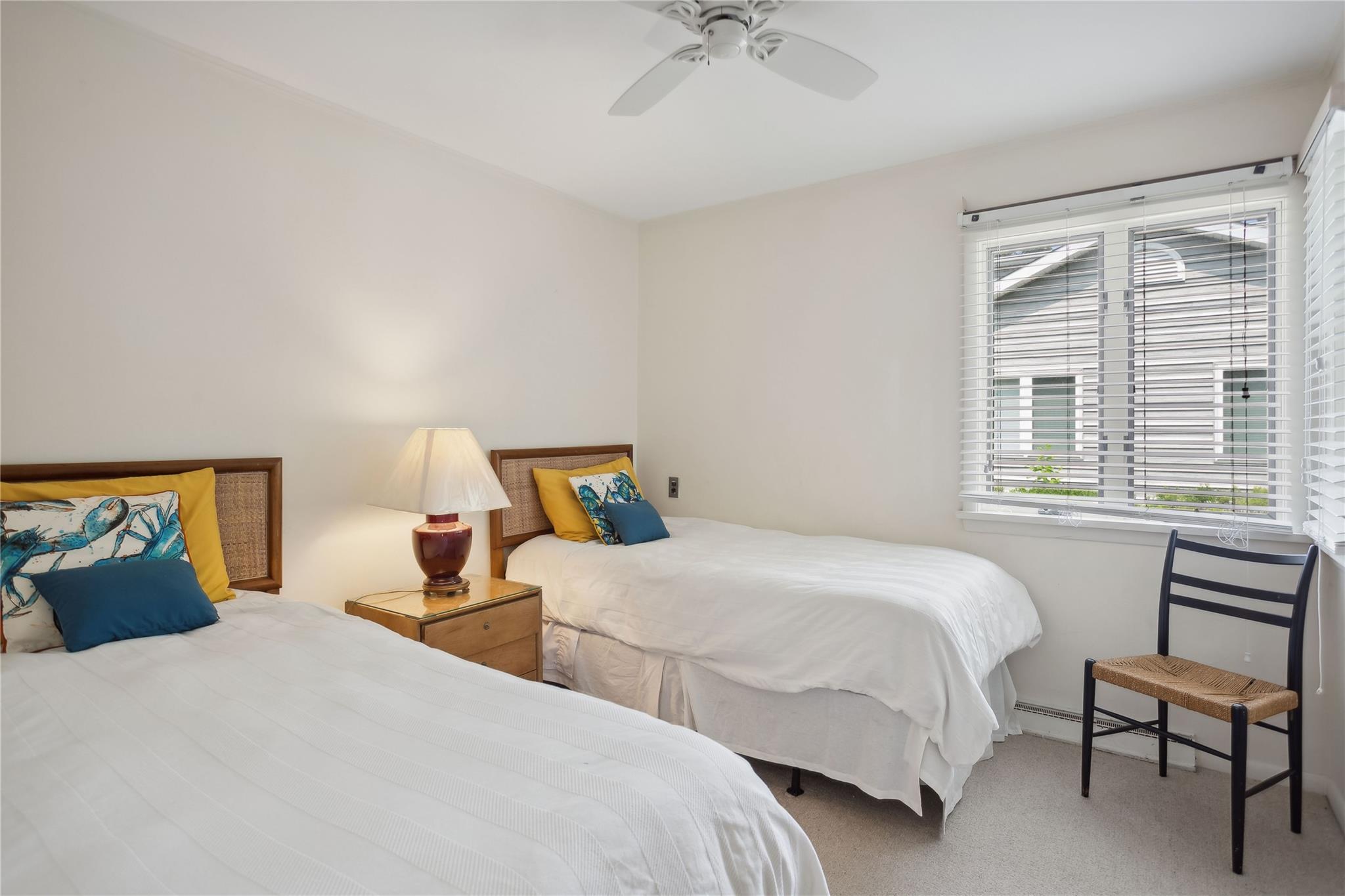 33 Beach Road Laurel, NY 11948 - Photo 15 of 38 a bedroom with two beds and a chandelier