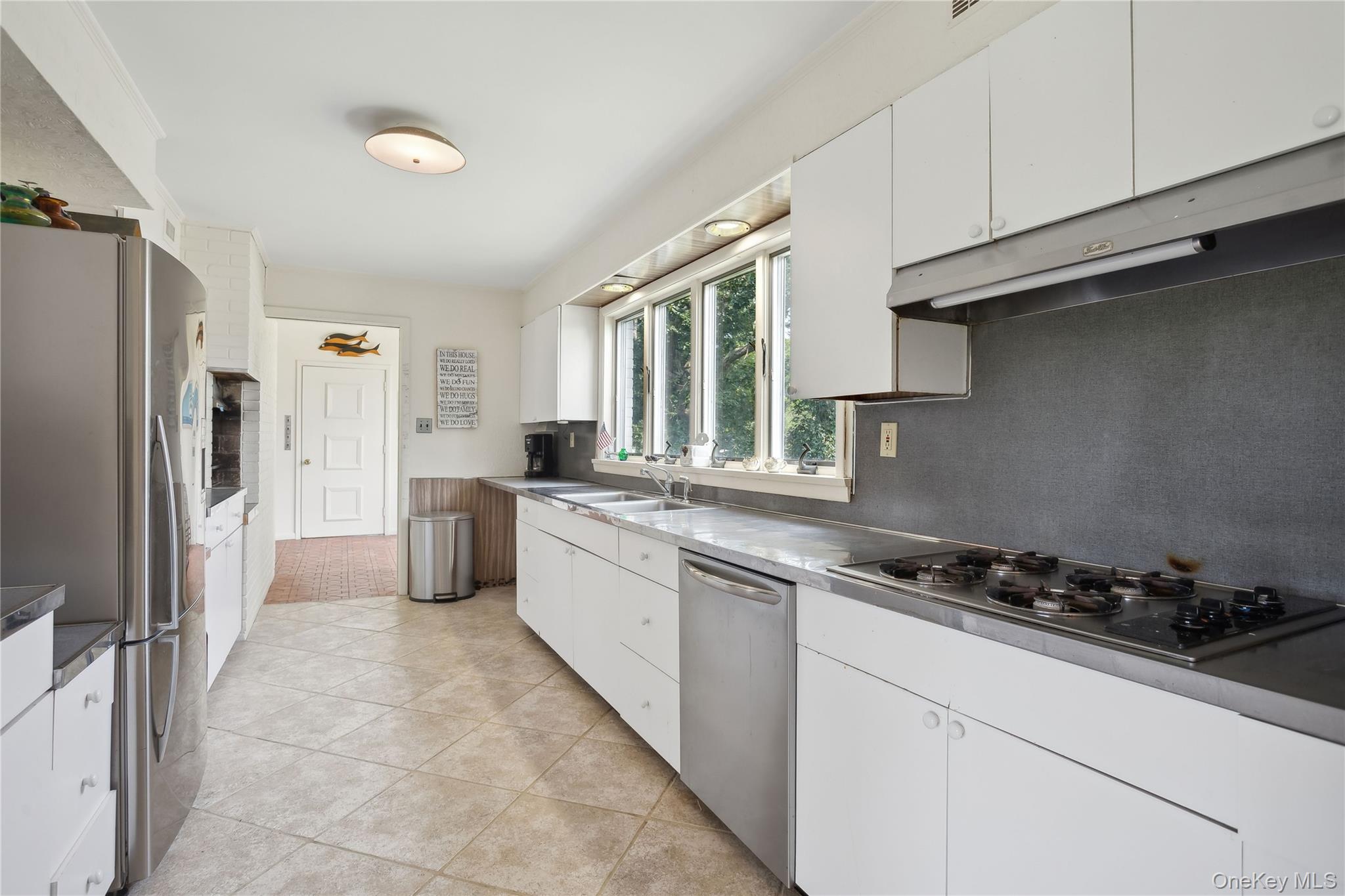 33 Beach Road Laurel, NY 11948 - Photo 22 of 38 a kitchen with stainless steel appliances a refrigerator sink and cabinets