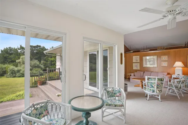 a dining room with furniture water view and a floor to ceiling window