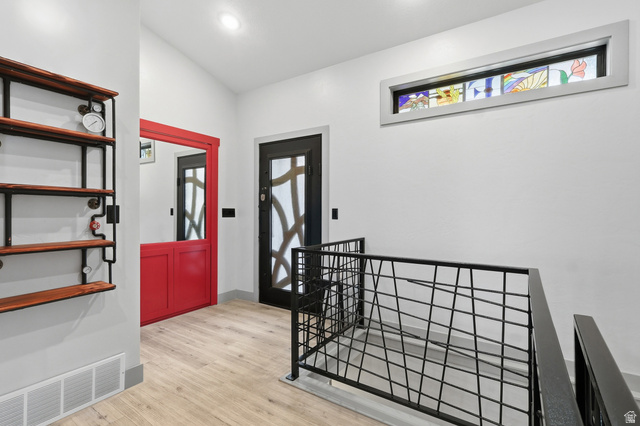175 North 100 West Providence, UT 84332 - Photo 2 of 45 Entrance foyer with light wood-type flooring, custom metal railing, a hidden door and vaulted ceiling
