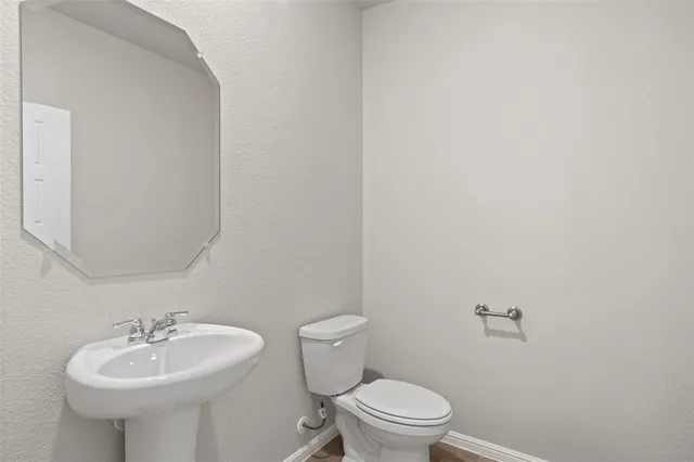a bathroom with a sink a toilet and mirror