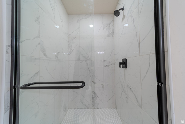 130 Pole Line Road, Unit 2 Roosevelt, UT 84066 - Photo 16 of 33 Glass-enclosed shower featuring white veined tile, a matte black shower head, and coordinating matte black fixtures