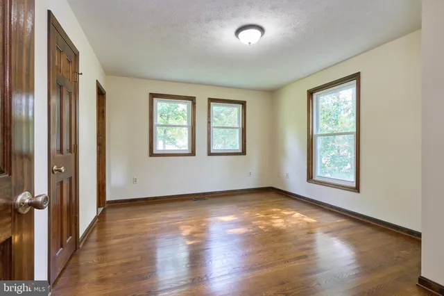 a view of an empty room with wooden floor