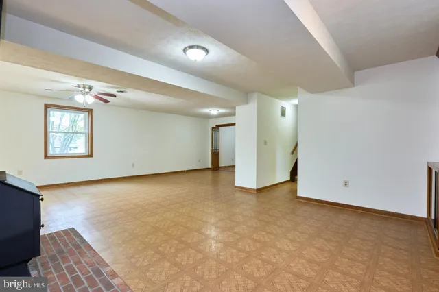 a view of an empty room with a fireplace and a window