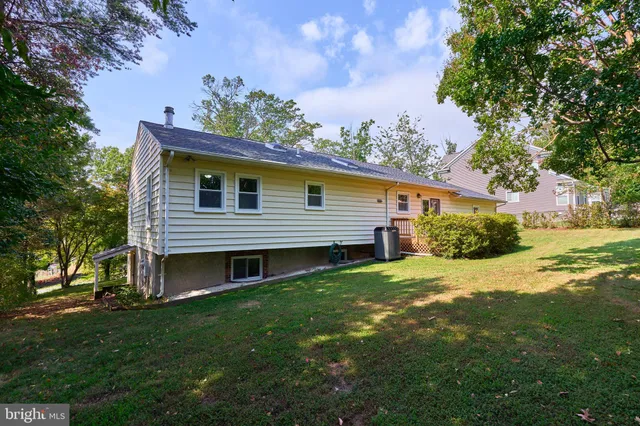 a view of a house with a big yard and large trees