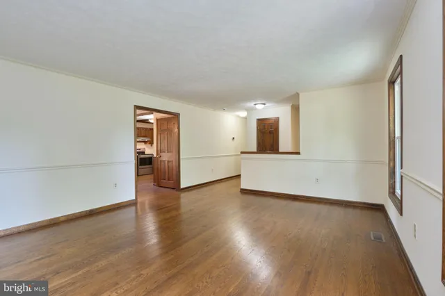 a view of a big room with wooden floor and windows
