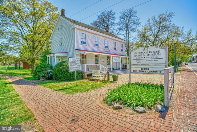 a front view of a building with cars parked