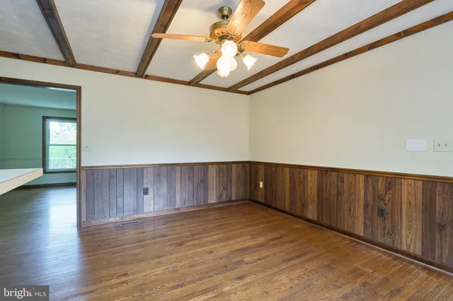 a view of a livingroom with wooden floor and a ceiling fan