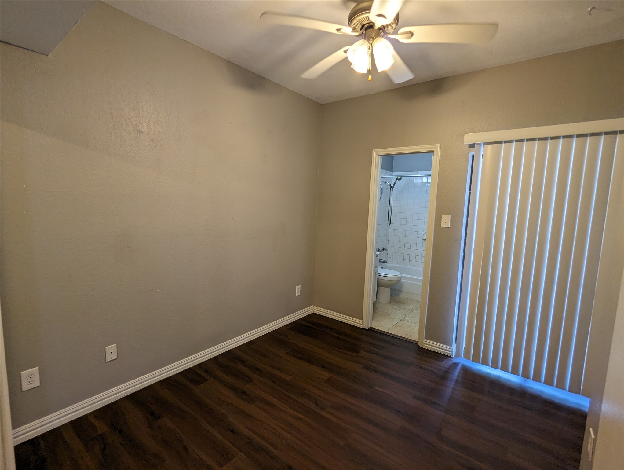 601 Nelray Boulevard, Unit 3 Austin, TX 78751 - Photo 8 of 12 an empty room with wooden floor fan and windows