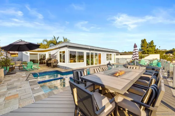 a view of a patio with table and chairs with wooden floor and fence