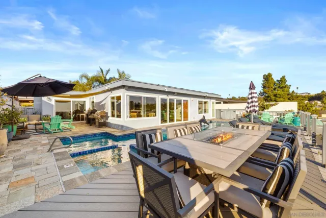 a view of a patio with table and chairs with wooden floor and fence