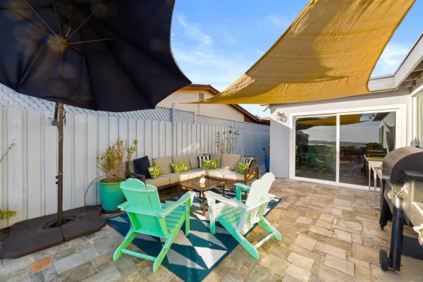 a patio with table and chairs and potted plants