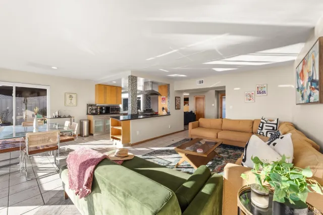 a living room with furniture and a dining table with kitchen view