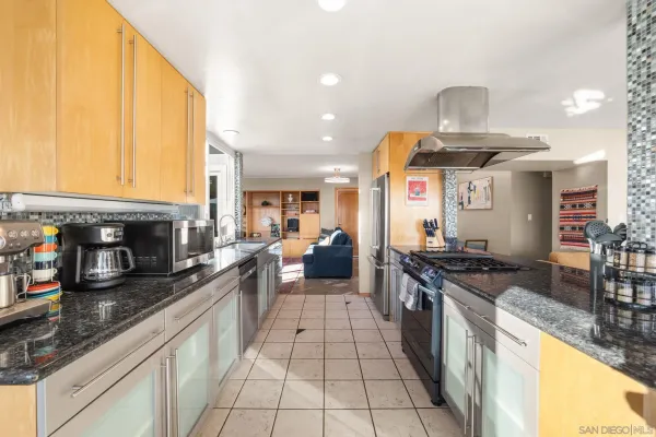 a large kitchen with stainless steel appliances granite countertop a stove and a sink