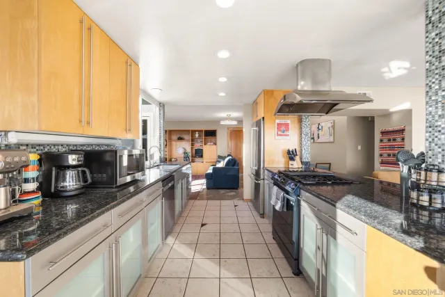 a large kitchen with stainless steel appliances granite countertop a stove and a sink