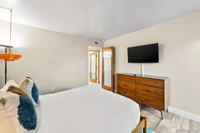 a bedroom with a bed and wooden floor