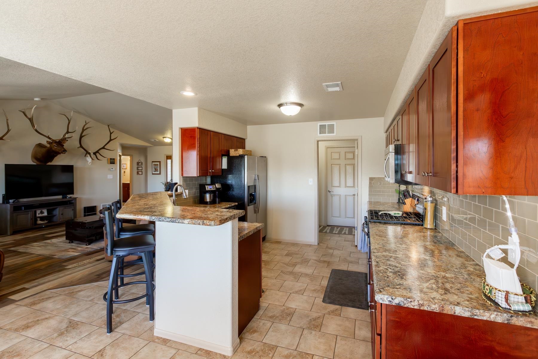 103 Red Rocks Street Fruita, CO 81521 - Photo 25 of 39 a kitchen with stainless steel appliances kitchen island granite countertop a refrigerator and a sink