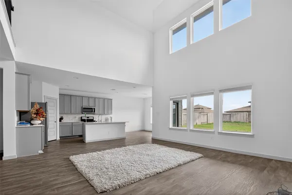 a kitchen that has a lot of white cabinets and wooden floor