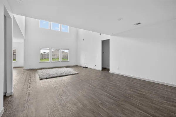 an entryway with wooden floor and a kitchen view