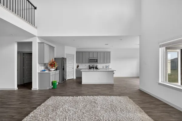 a kitchen with a sink a microwave a refrigerator and cabinets