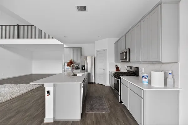 a kitchen with stainless steel appliances a refrigerator sink and cabinets