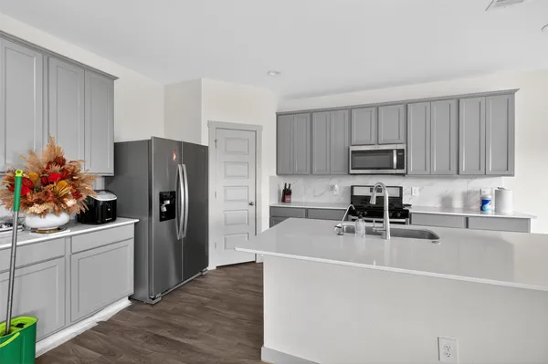 a kitchen with stainless steel appliances a sink a stove cabinets and a kitchen island