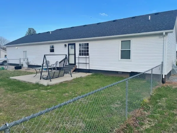 a view of a house with backyard and sitting area