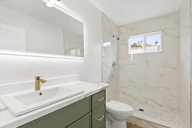 a bathroom with a sink a toilet and a mirror