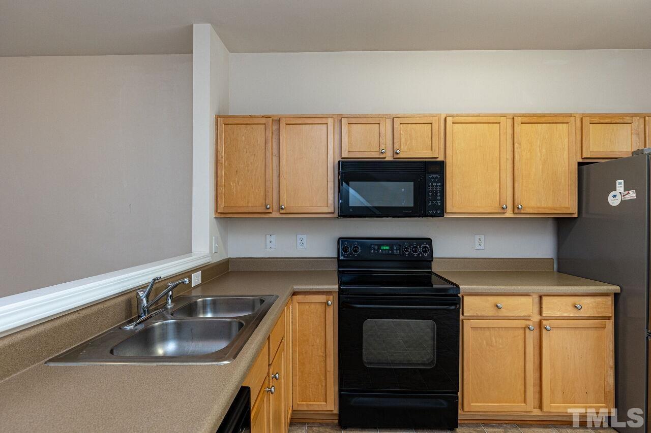 1730 Sorrell Brook Way Raleigh, NC 27609 - Photo 11 of 30 a kitchen with granite countertop white cabinets sink and stainless steel appliances