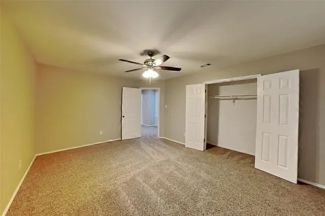 a view of an empty room with a ceiling fan