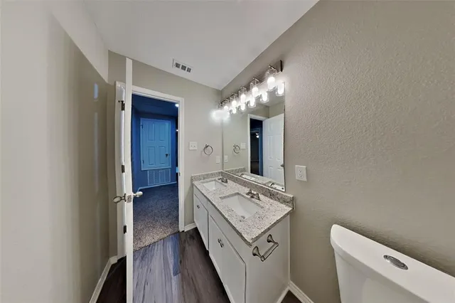 a bathroom with a sink a toilet and mirror