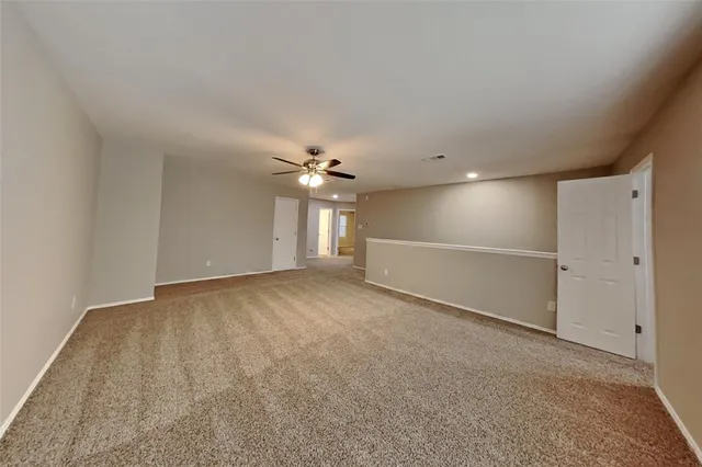 a view of an empty room with a ceiling fan