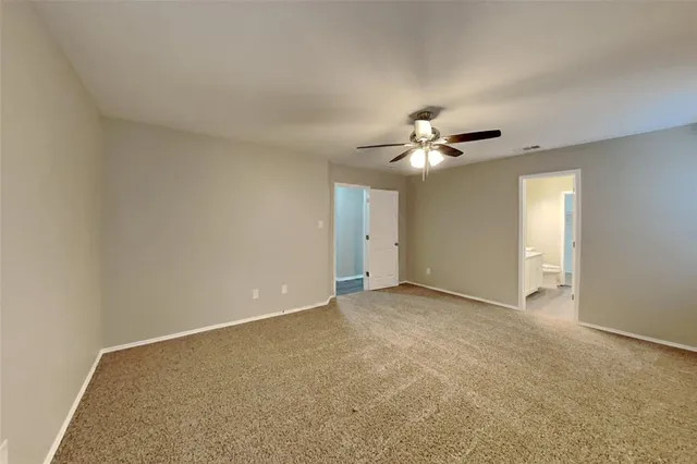 an empty room with a ceiling fan and a window