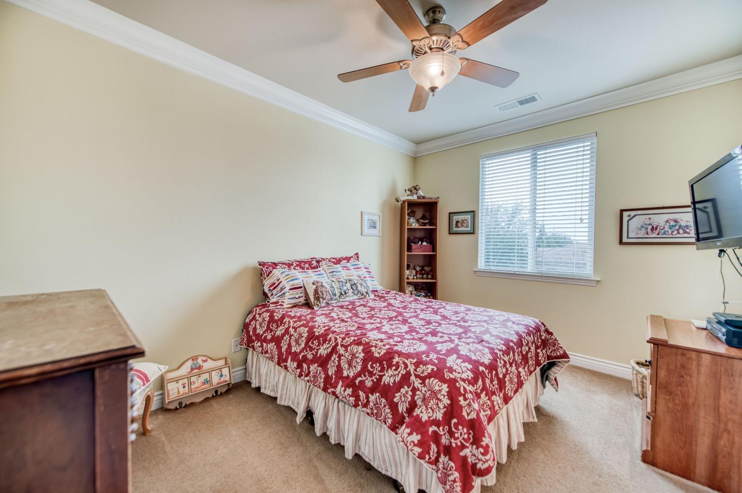 3207 Dennis Avenue Clovis, CA 93619 - Photo 23 of 55 a bedroom with a bed and a dresser with rug