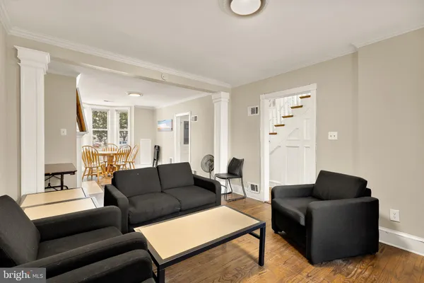 a living room with furniture and a wooden floor