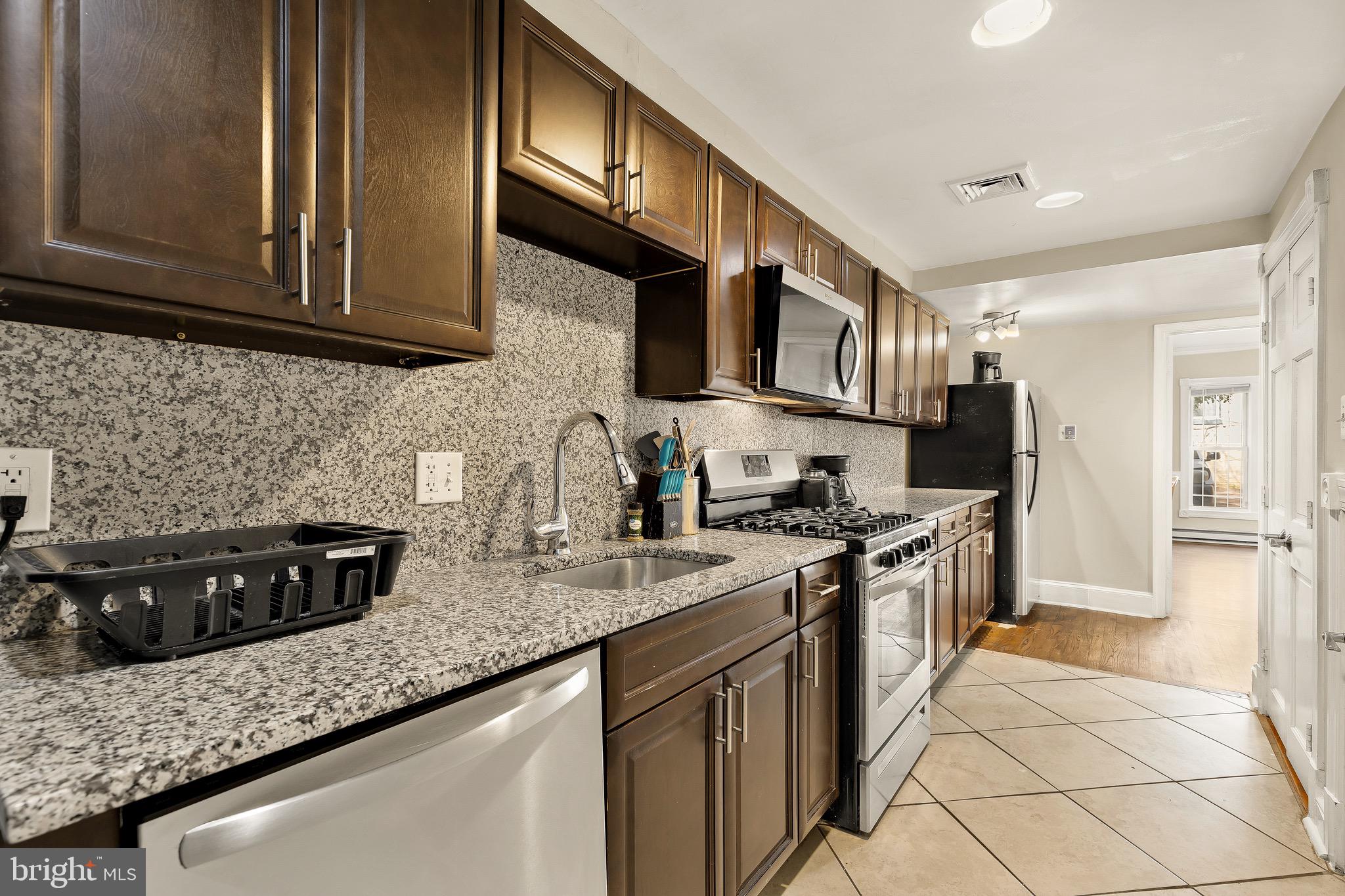 228 East Capitol Street Northeast Washington, DC 20003 - Photo 8 of 27 a kitchen with stainless steel appliances granite countertop a stove a sink and a microwave