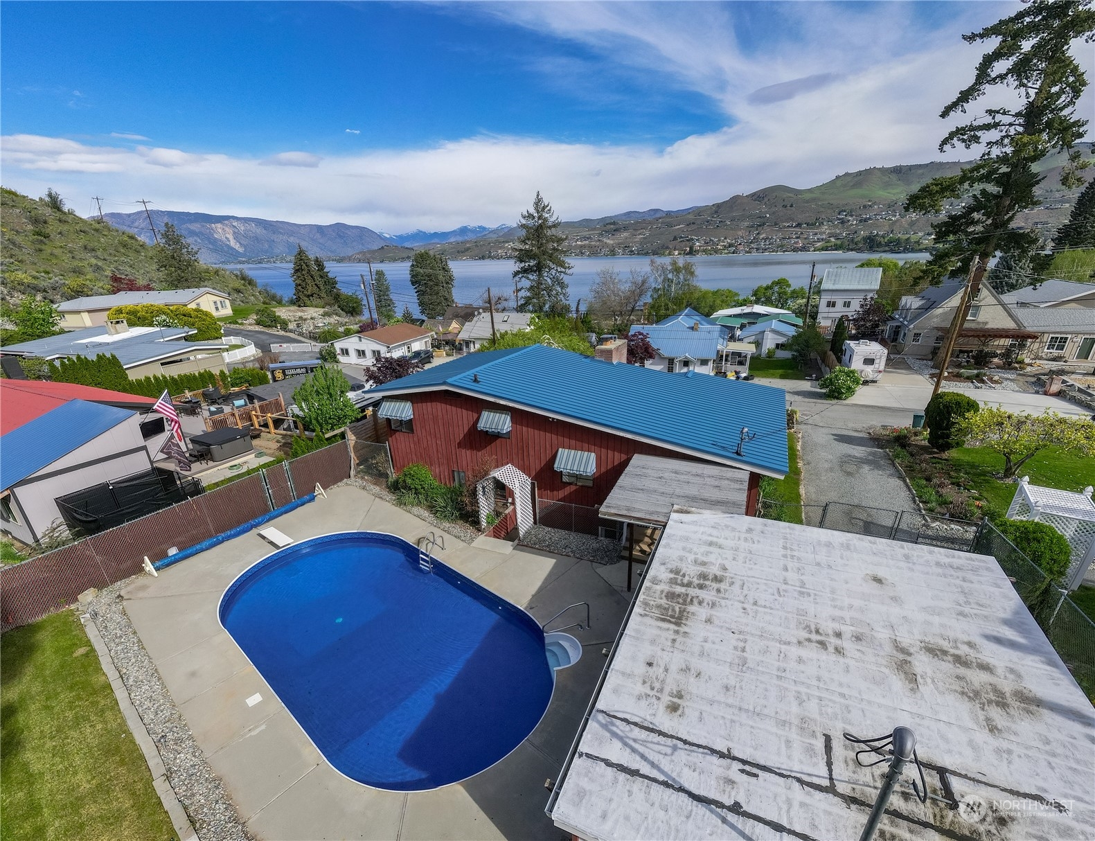 an aerial view of a house with a swimming pool yard and mountain view in back