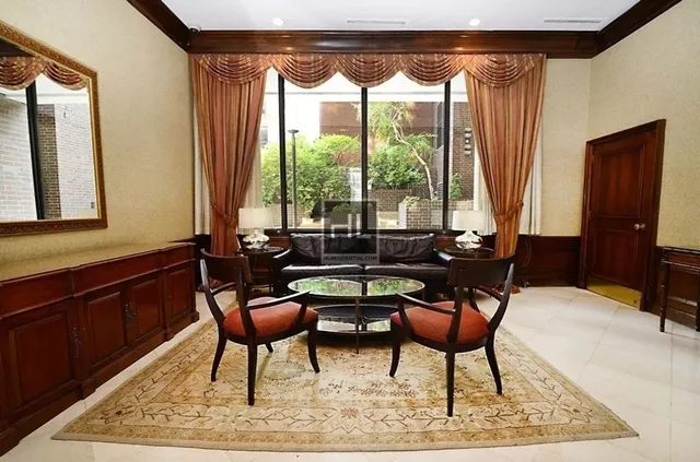 a dining room with furniture and a large window
