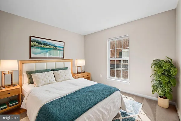 a bedroom with a large bed and a potted plant
