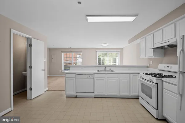 a kitchen with white cabinets and white appliances